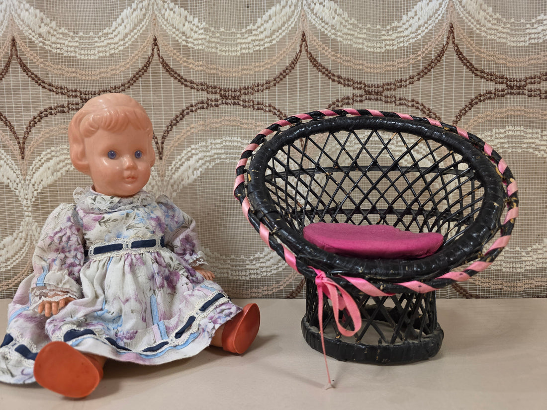 Zwart vintage rieten poppenstoeltje met roze kussentje en roze lint