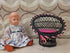 Zwart vintage rieten poppenstoeltje met roze kussentje en roze lint